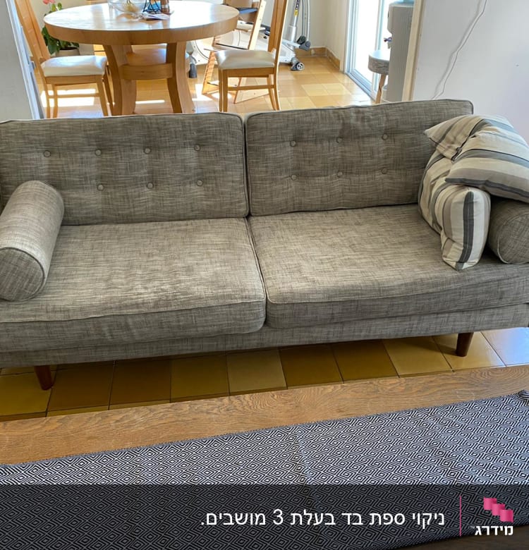 ספה אפורה עם כריות על רצפת אריחים